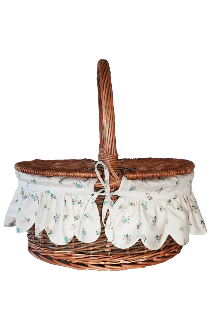 Wicker picnic basket with floral fabric liner on a white background