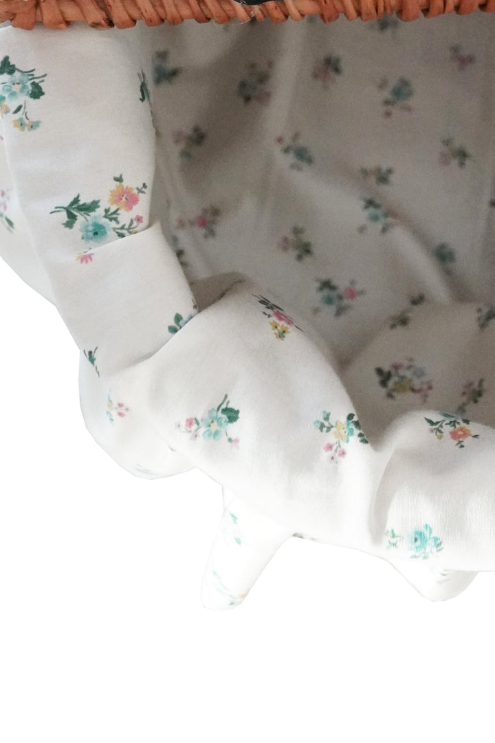 Floral-patterned fabric with a wicker basket in the background