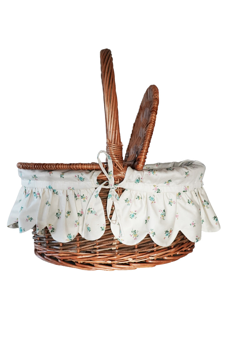 Wicker basket with floral fabric liner on a white background