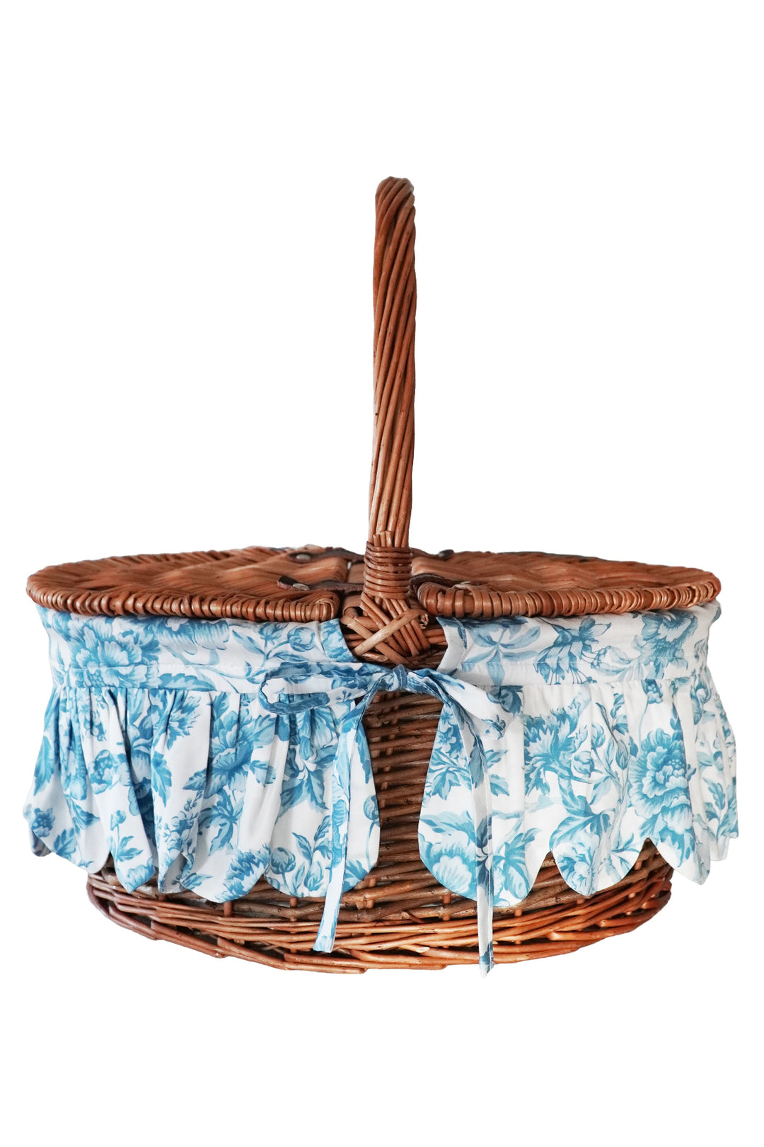 Wicker picnic basket with floral fabric liner on a white background