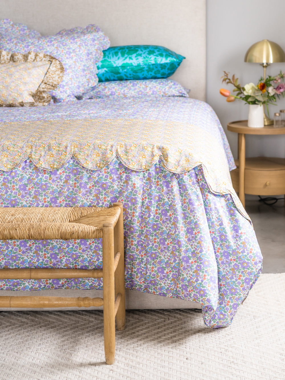purple and mustard floral bedding called betsy on a bed by coco and wolf