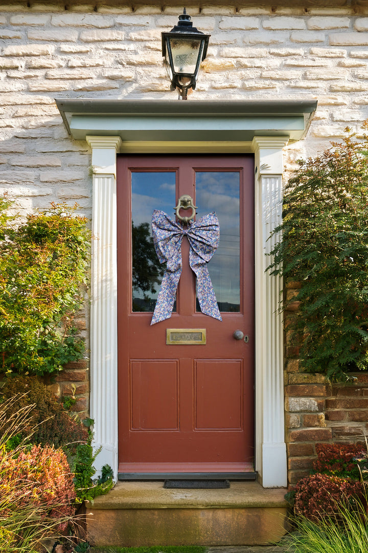 Red door with a decorative bow on a stone building