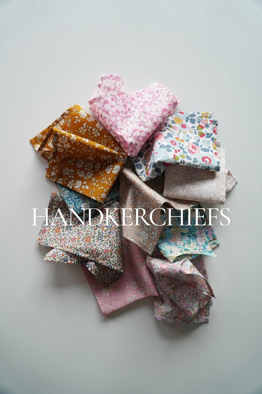 Collection of colorful handkerchiefs on a light gray background with 'HANDKERCHIEFS' text.