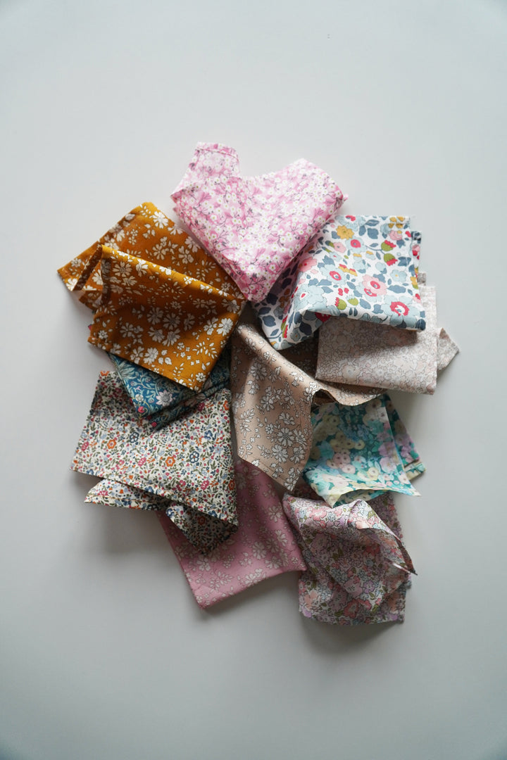 Stack of colorful fabric squares on a light gray background