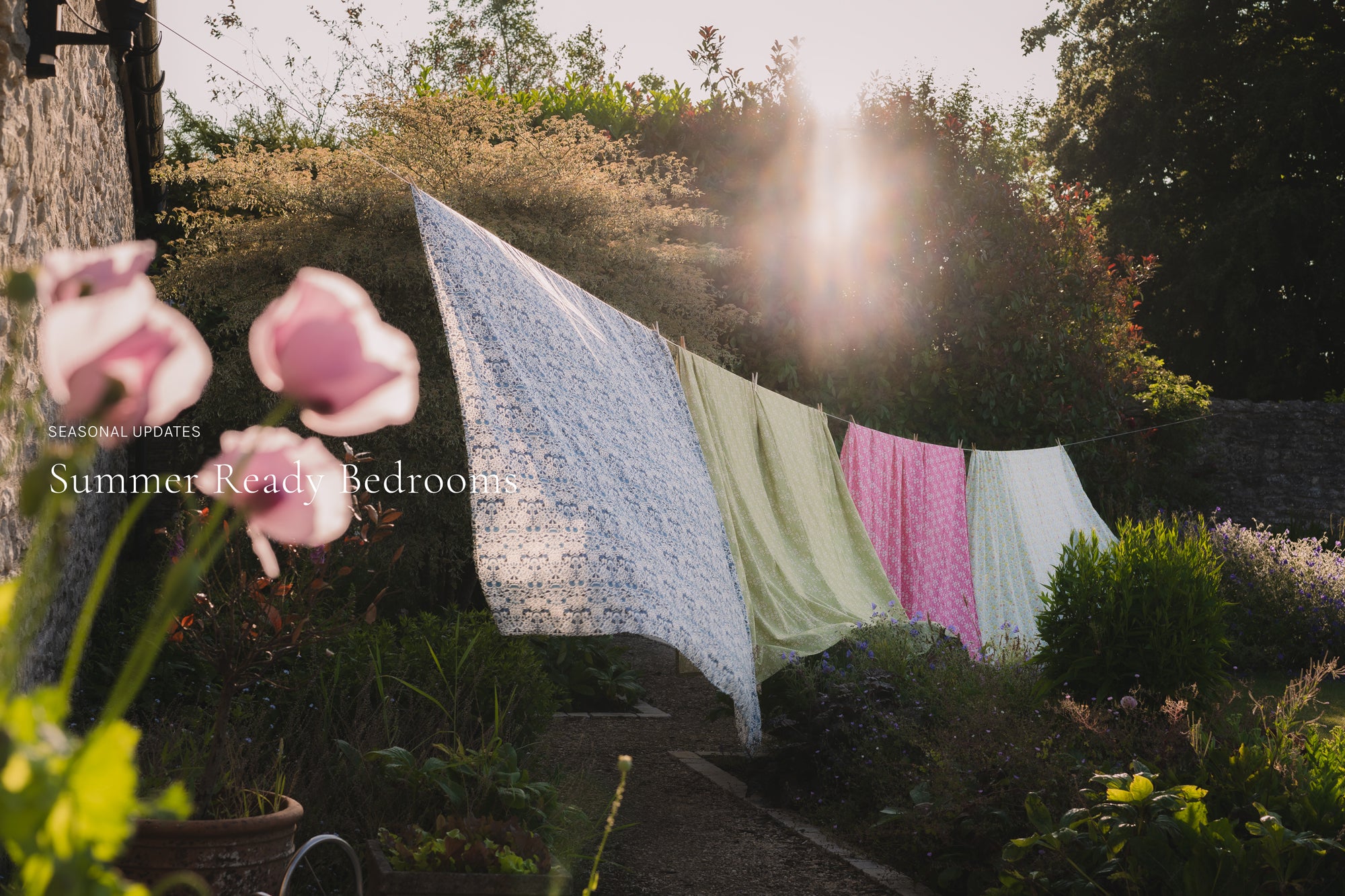 summer ready bedroom image of duvets hanging on a washing line in a sunshine flooded garden
